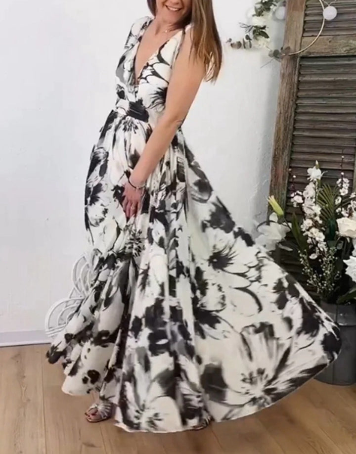 Women’s voluminous A-line maxi dress with deep V-neck, tailored tie belt and large floral brush print Mune Fashion