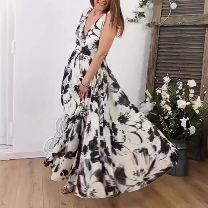 Women’s voluminous A-line maxi dress with deep V-neck, tailored tie belt and large floral brush print Mune Fashion