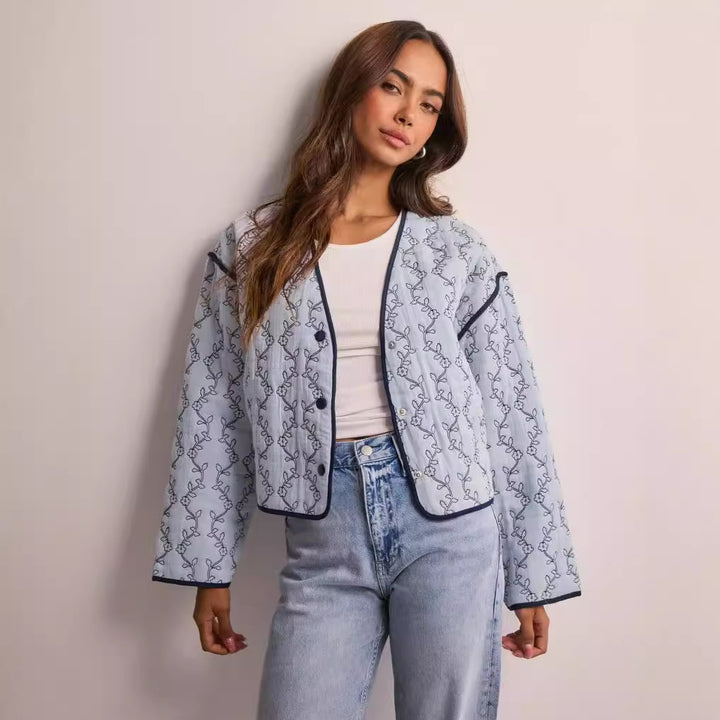 Women's quilted short jacket with V-neck, contrast piping, and floral quilted application Mune Fashion