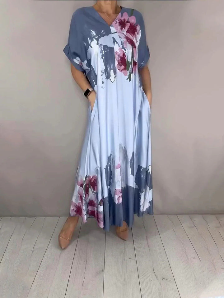 Women's maxi dress with a flowing fall, V-neck, side pockets, and floral watercolor look Mune Fashion