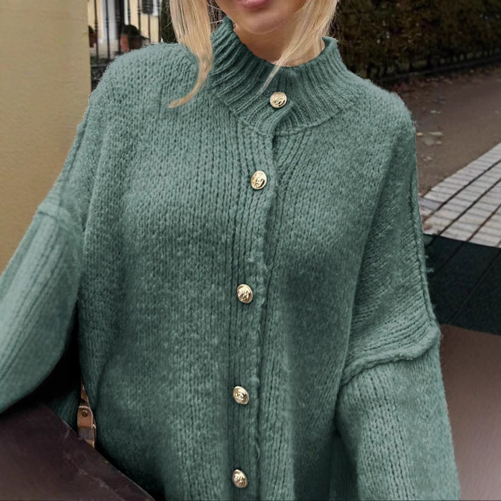 Women’s oversized knit cardigan made of chunky knit with ribbed round neck, dropped shoulders, and wooden button placket.