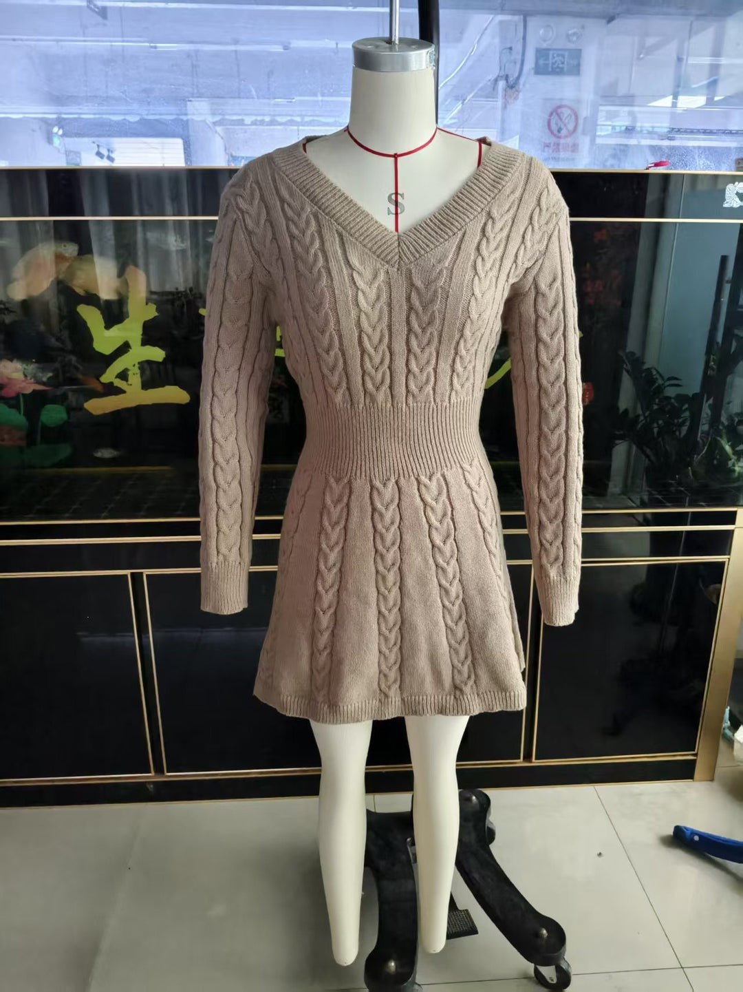 Women's figure-hugging knit dress with cable knit structure, V-neckline and tailored peplum shape Mune Fashion