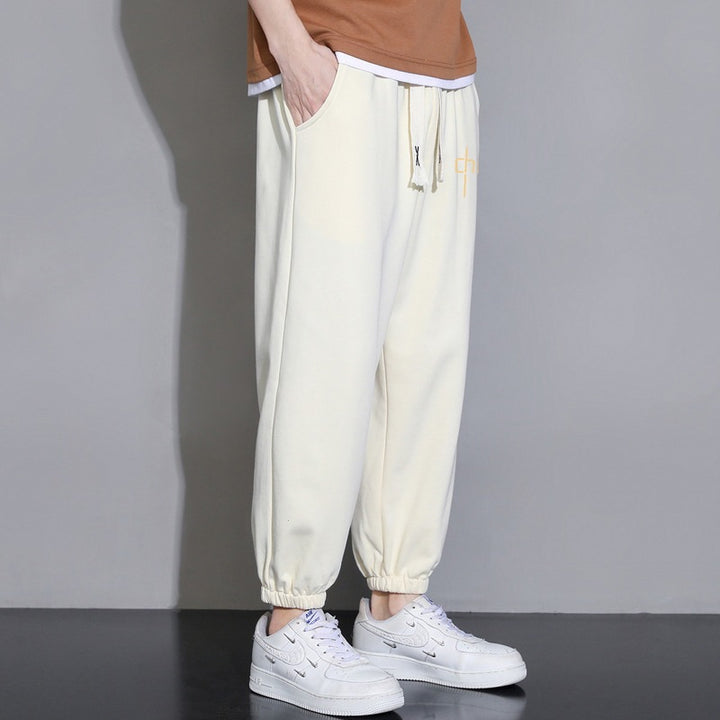 Men's loose fitting sweatpants with drawstring, elastic cuffs, and side pockets Mune Fashion
