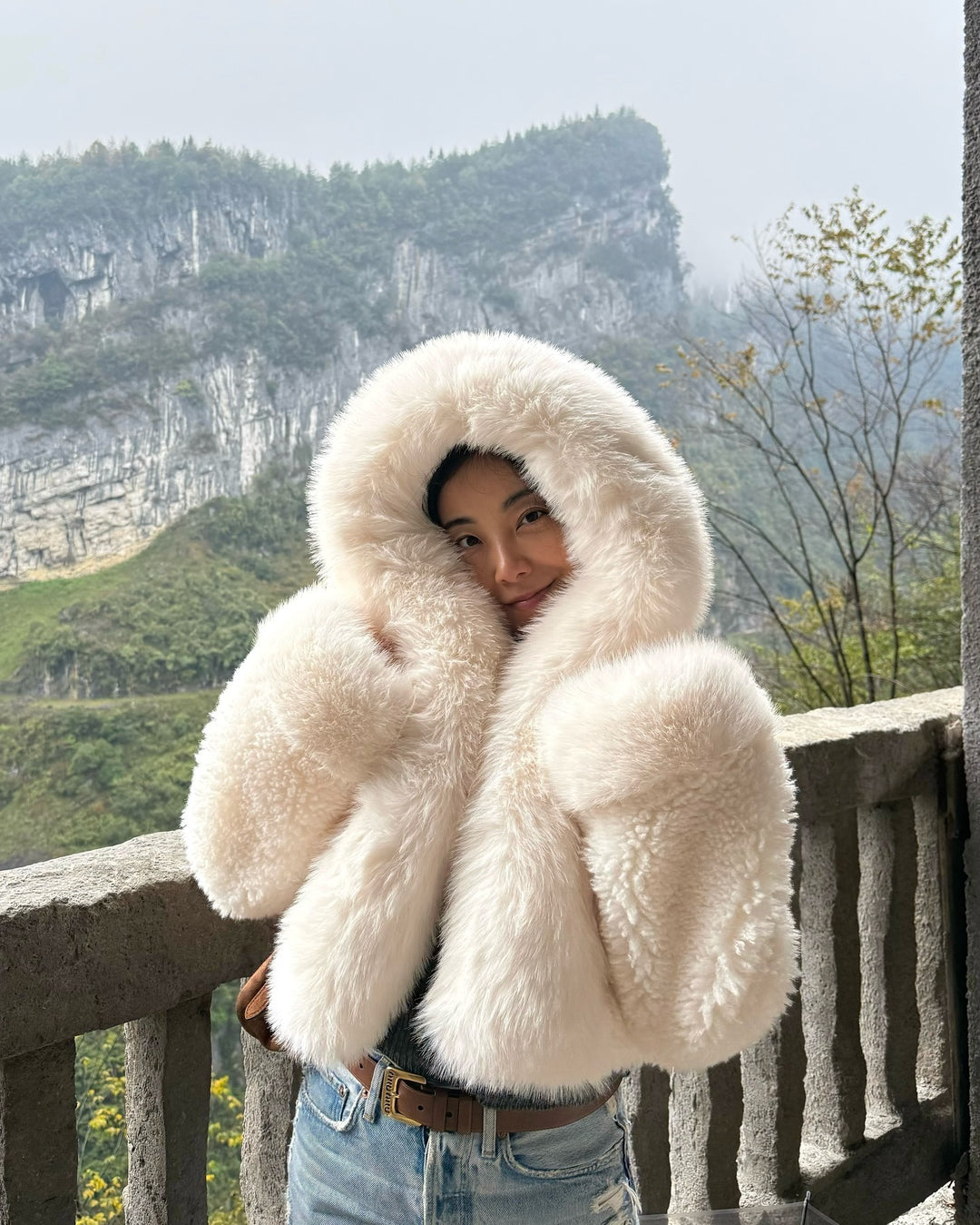 Women's short jacket made of voluminous faux fur with XXL hood and ball sleeves Mune Fashion