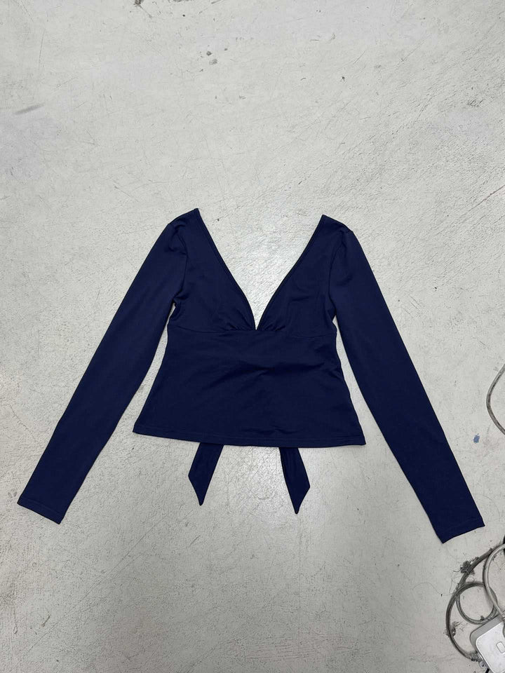 Women's fitted long-sleeve top with deep V-neck, shaped bust area, and tie detail Mune Fashion