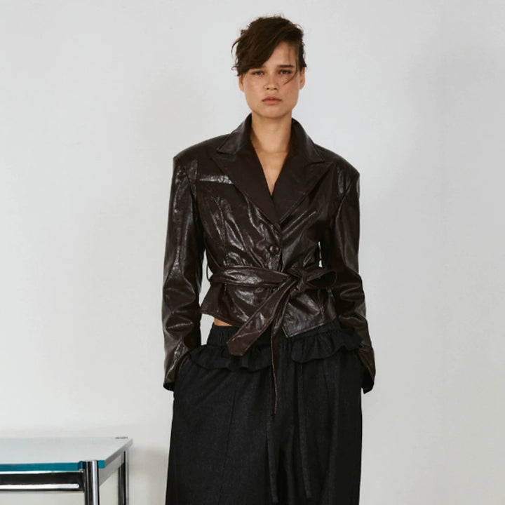 Women’s short blazer in patent leather look with waist belt and flowing lapel Mune Fashion