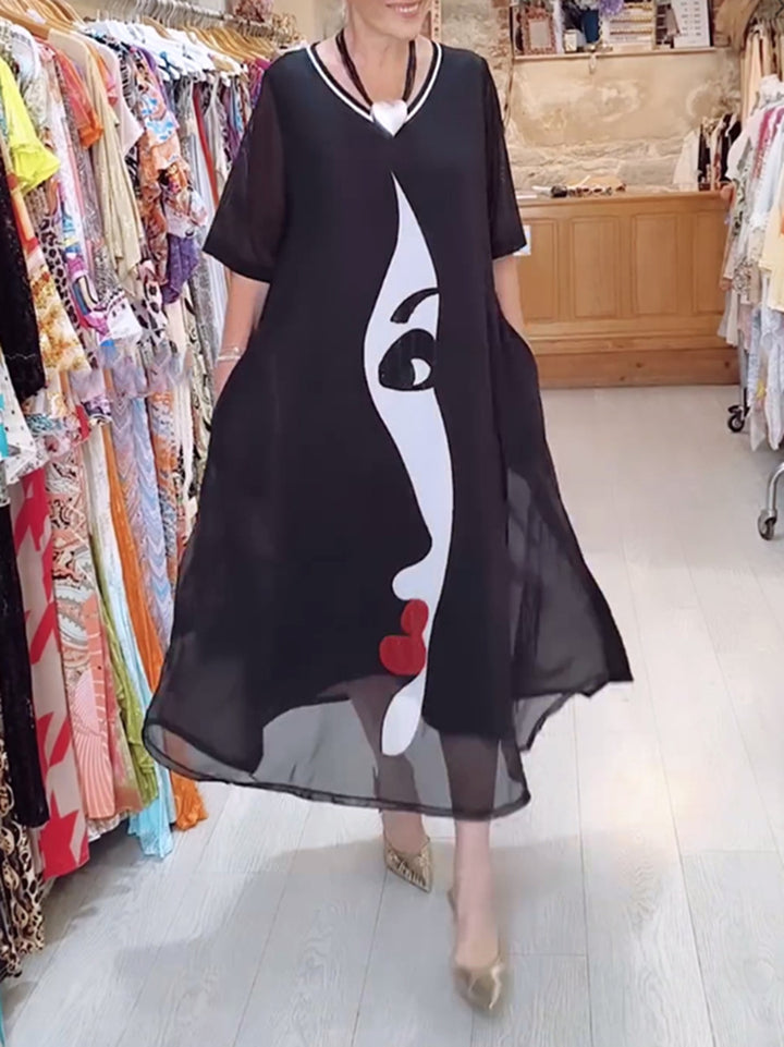 Women's airy chiffon maxi dress with graphic face print, V-neck and side pockets Mune Fashion