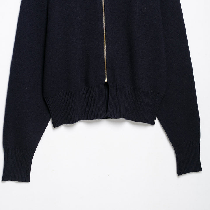 Women's cropped fine-knit cardigan with standing collar, full-length zipper, and fitted ribbed section.