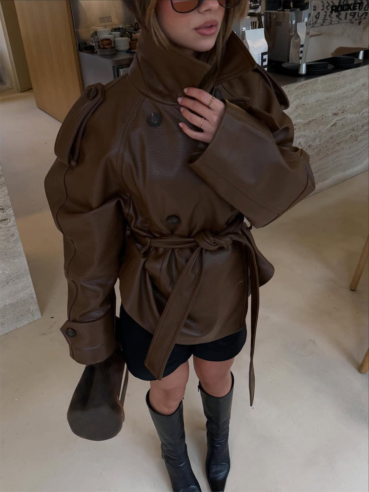 Women’s short cut oversized faux leather trench coat with waist belt and epaulettes Mune Fashion