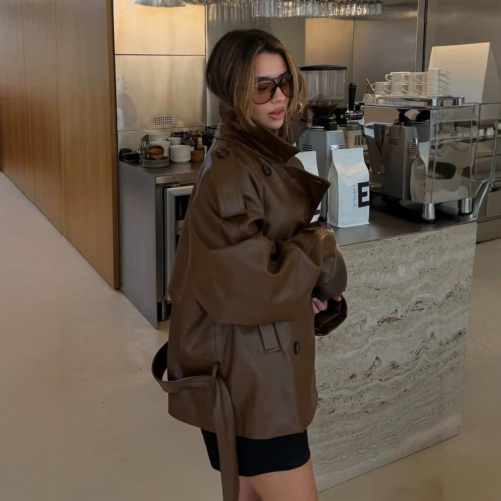 Women’s short cut oversized faux leather trench coat with waist belt and epaulettes Mune Fashion