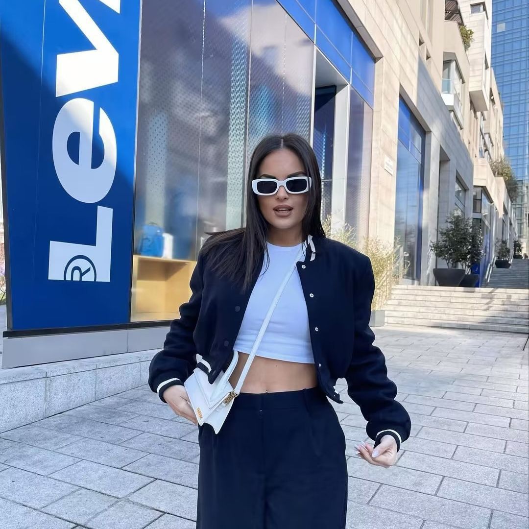 Women nan short college bomber jacket with snap button closure, ribbed stripe waistband and side pockets Mune Fashion
