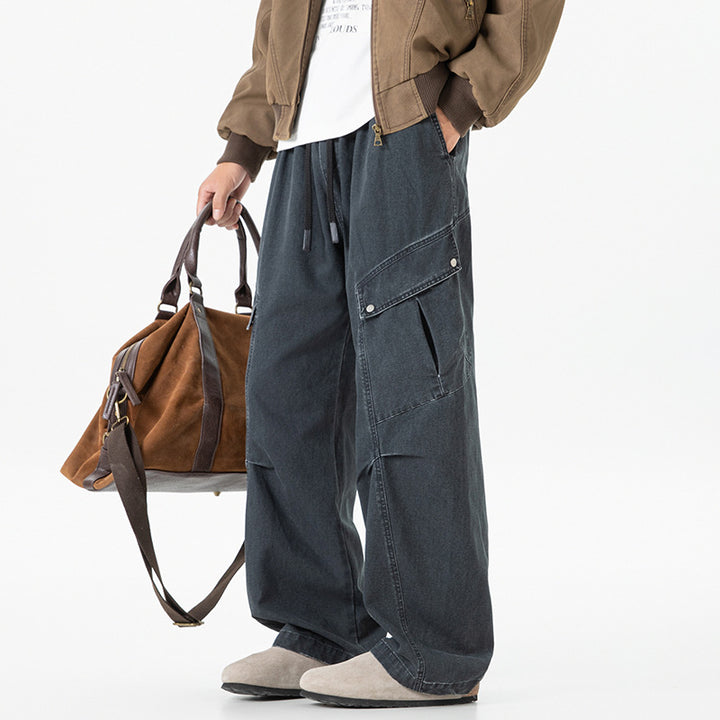 Men's loose utility cargo pants in baggy cut with drawstring waistband and large flap pockets.