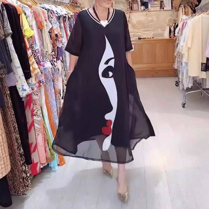 Women's airy chiffon maxi dress with graphic face print, V-neck and side pockets Mune Fashion