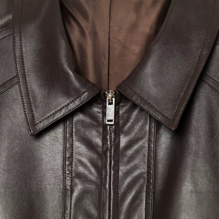 Women's short jacket in leather look with oversized shirt collar, flap pockets, and gathered hem.