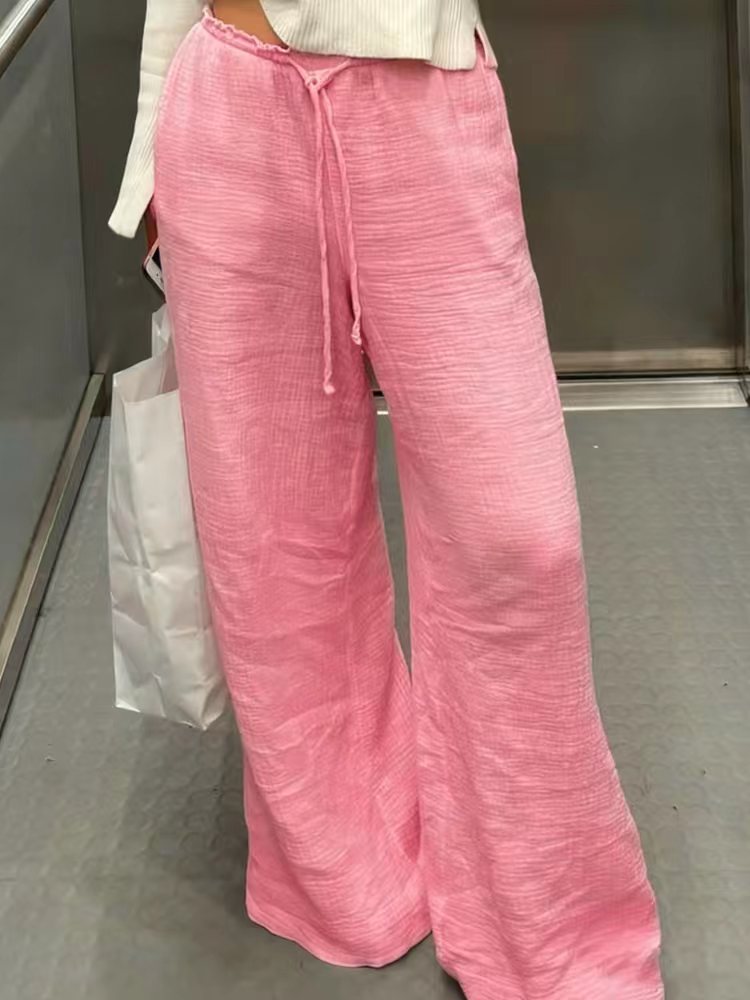 Women's linen trousers with a relaxed, ankle-length fit, side pockets and decorative button details Mune Fashion