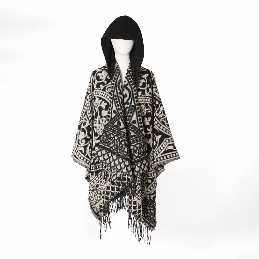 Women’s hooded cape poncho made of wool blend with jacquard pattern, fringes and oversized drape.