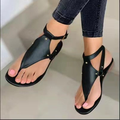 Women’s flat T-strap thong sandals with adjustable ankle strap and decorative floral appliqué in faux leather Mune Fashion