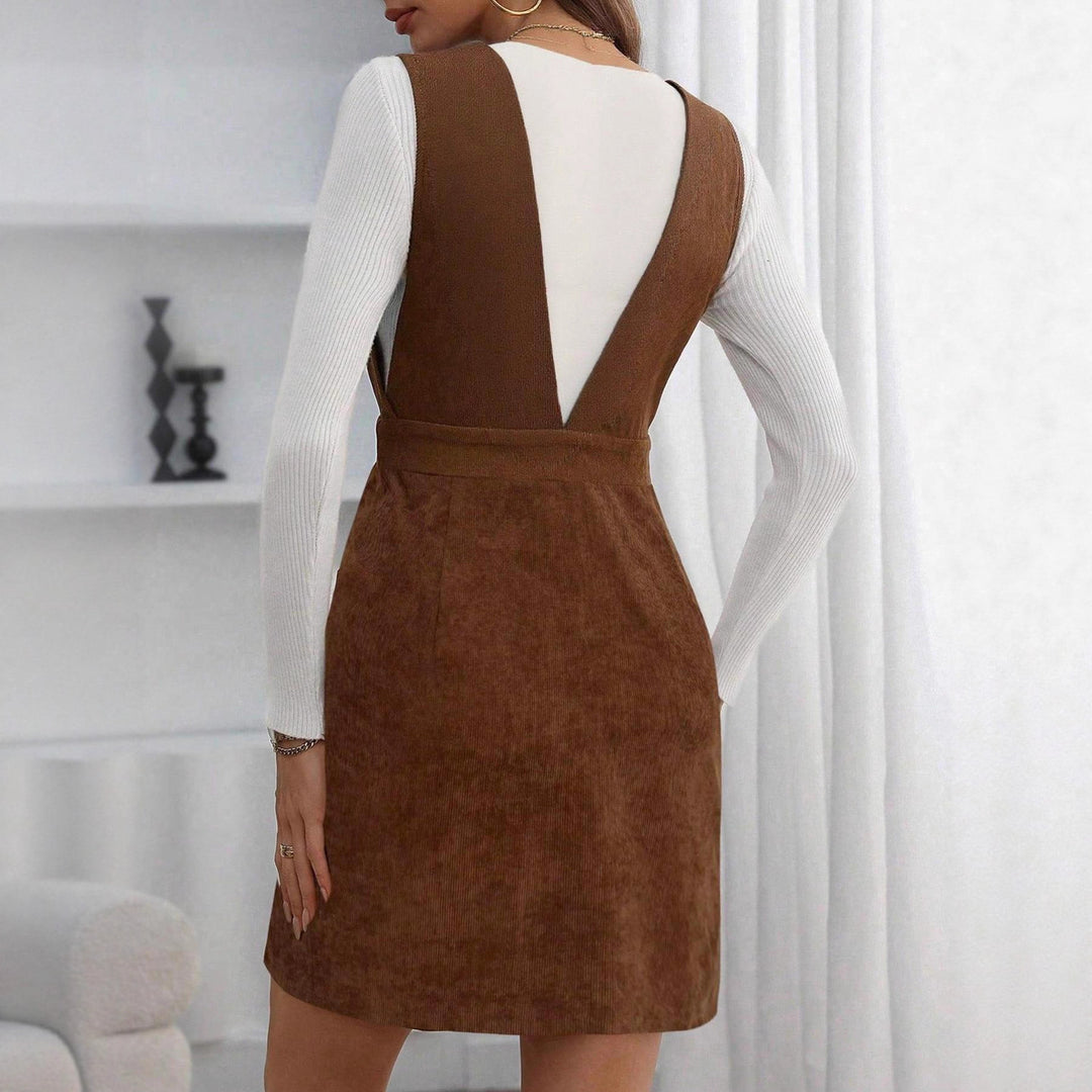 Women's cord overall dress with deep V-neck, waist belt, and A-line design