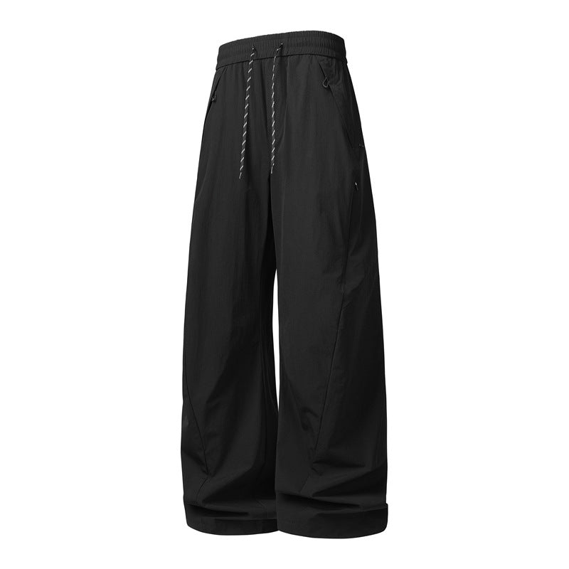 Unisex Wide Tech Baggy Pants with elastic drawstring, zip pockets & water-repellent nylon look Mune Fashion