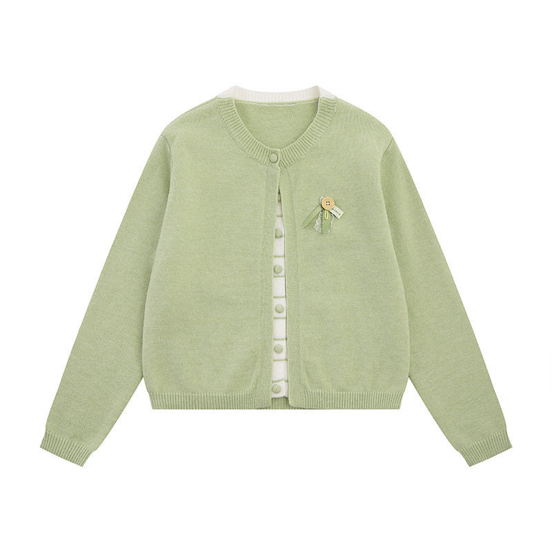 Ladies fine knit cardigan with round neckline, concealed button placket, and decorative brooch Mune Fashion