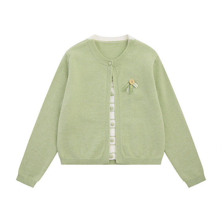 Ladies fine knit cardigan with round neckline, concealed button placket, and decorative brooch Mune Fashion