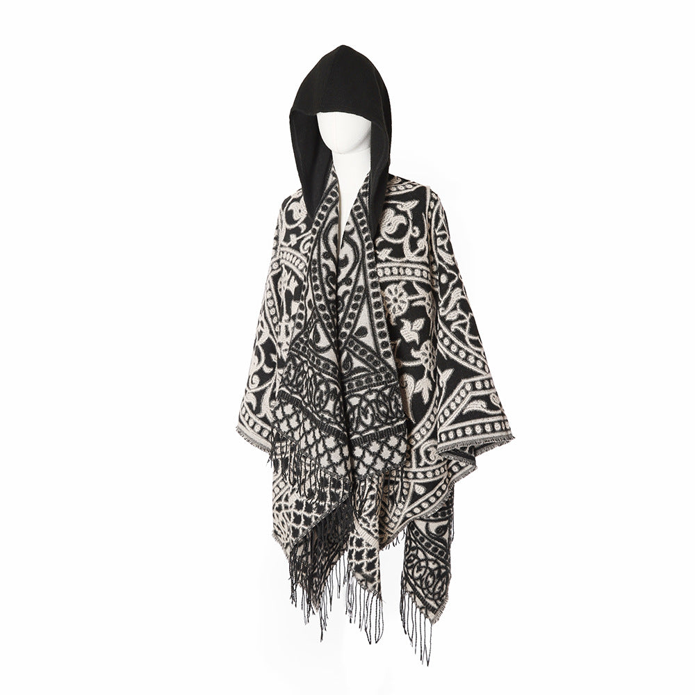 Women’s hooded cape poncho made of wool blend with jacquard pattern, fringes and oversized drape.