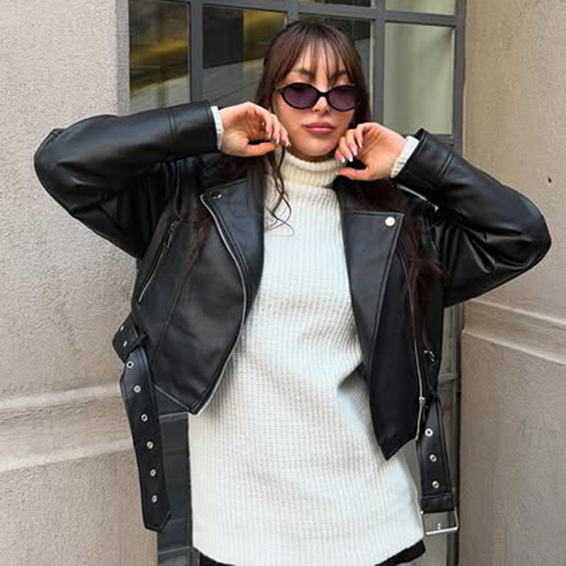 Women's fitted biker jacket made of faux leather with asymmetrical zipper, metallic details, and waist belt Mune Fashion