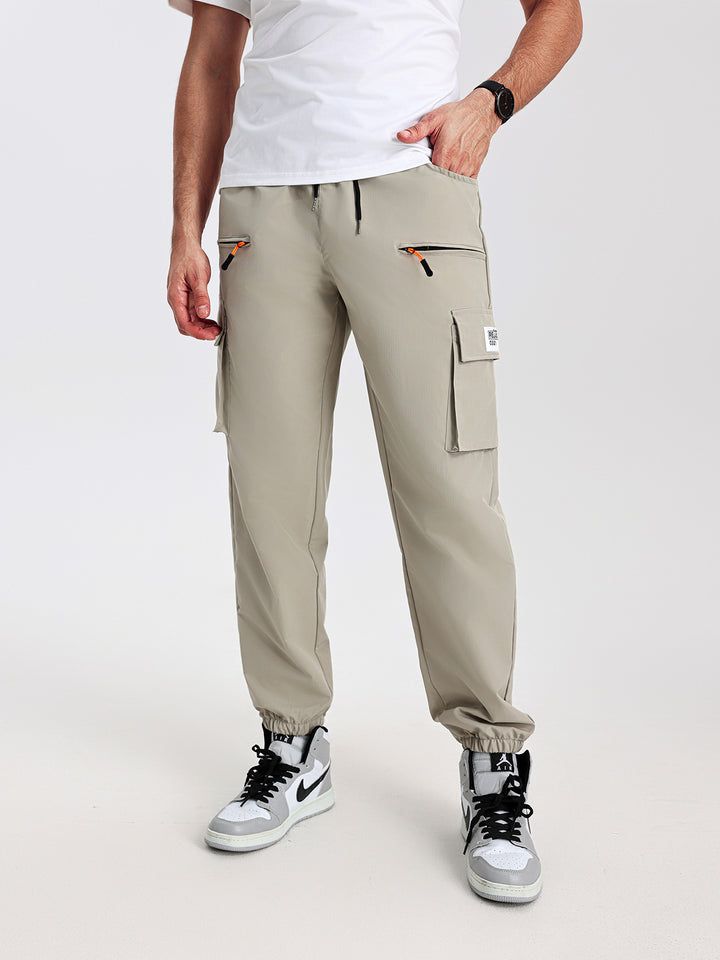 Men's tapered cut utility cargo pants in jogger style with drawstring waistband, zippered pockets & elastic leg cuffs Mune Fashion