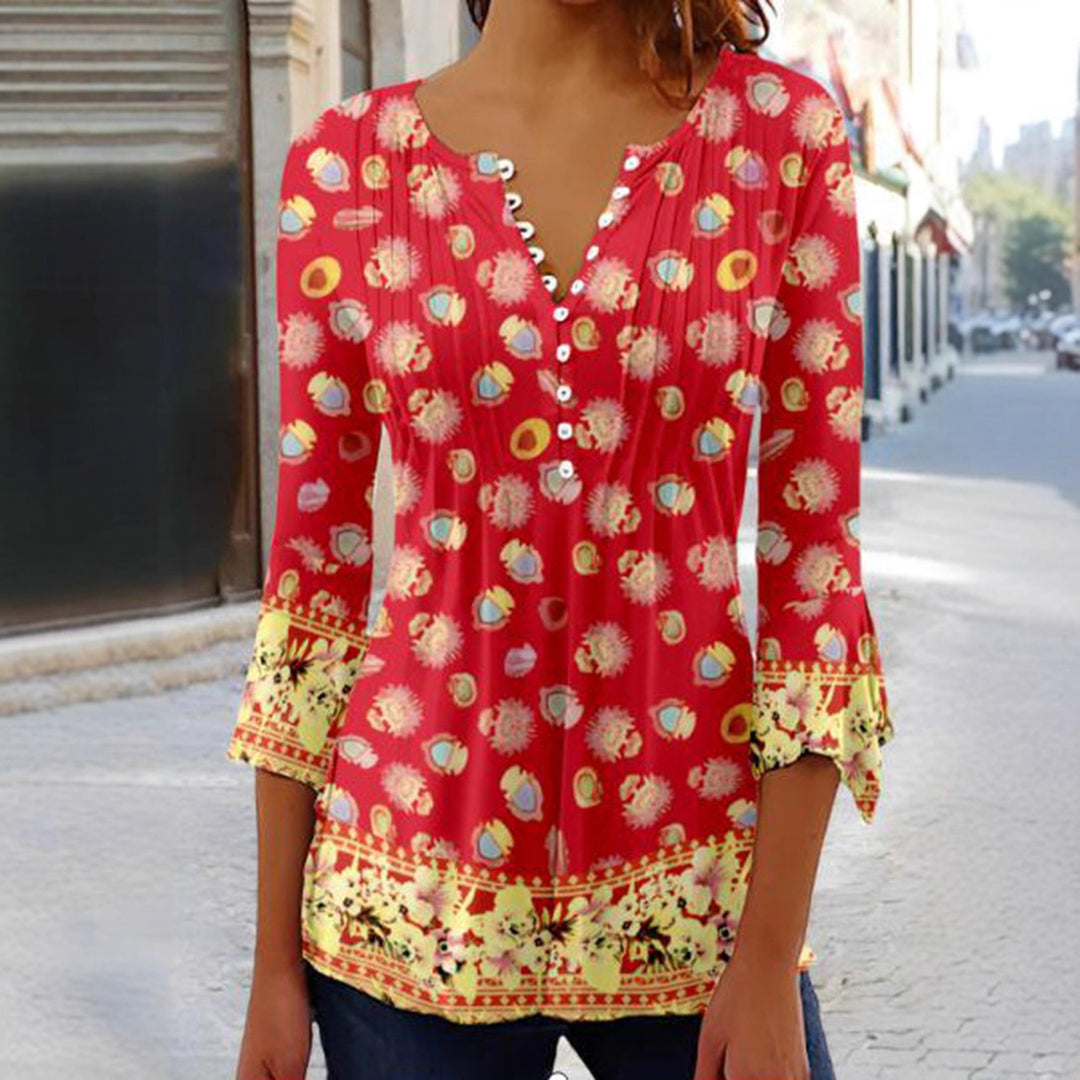 Women's flowing V-neck tunic with decorative button placket, chest pleats, three-quarter sleeves, and floral border edge Mune Fashion