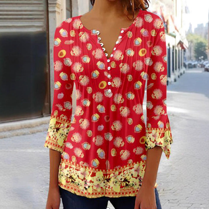 Women's flowing V-neck tunic with decorative button placket, chest pleats, three-quarter sleeves, and floral border edge Mune Fashion