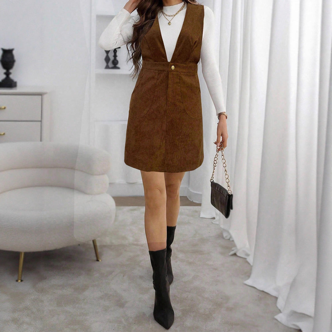 Women's cord overall dress with deep V-neck, waist belt, and A-line design