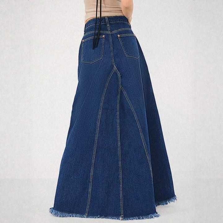 Women’s high-waisted A-line denim maxi skirt with decorative seams and raw fringe hem Mune Fashion