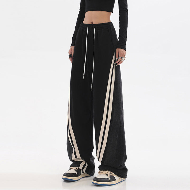 Ladies loose-fitting jogging pants with denim inserts, elastic waistband, and side contrast stripes Mune Fashion