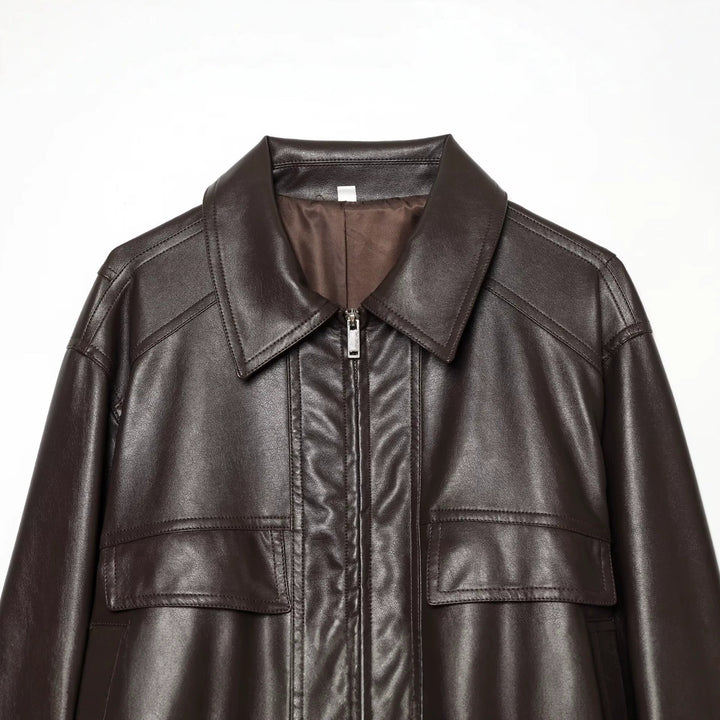 Women's short jacket in leather look with oversized shirt collar, flap pockets, and gathered hem.